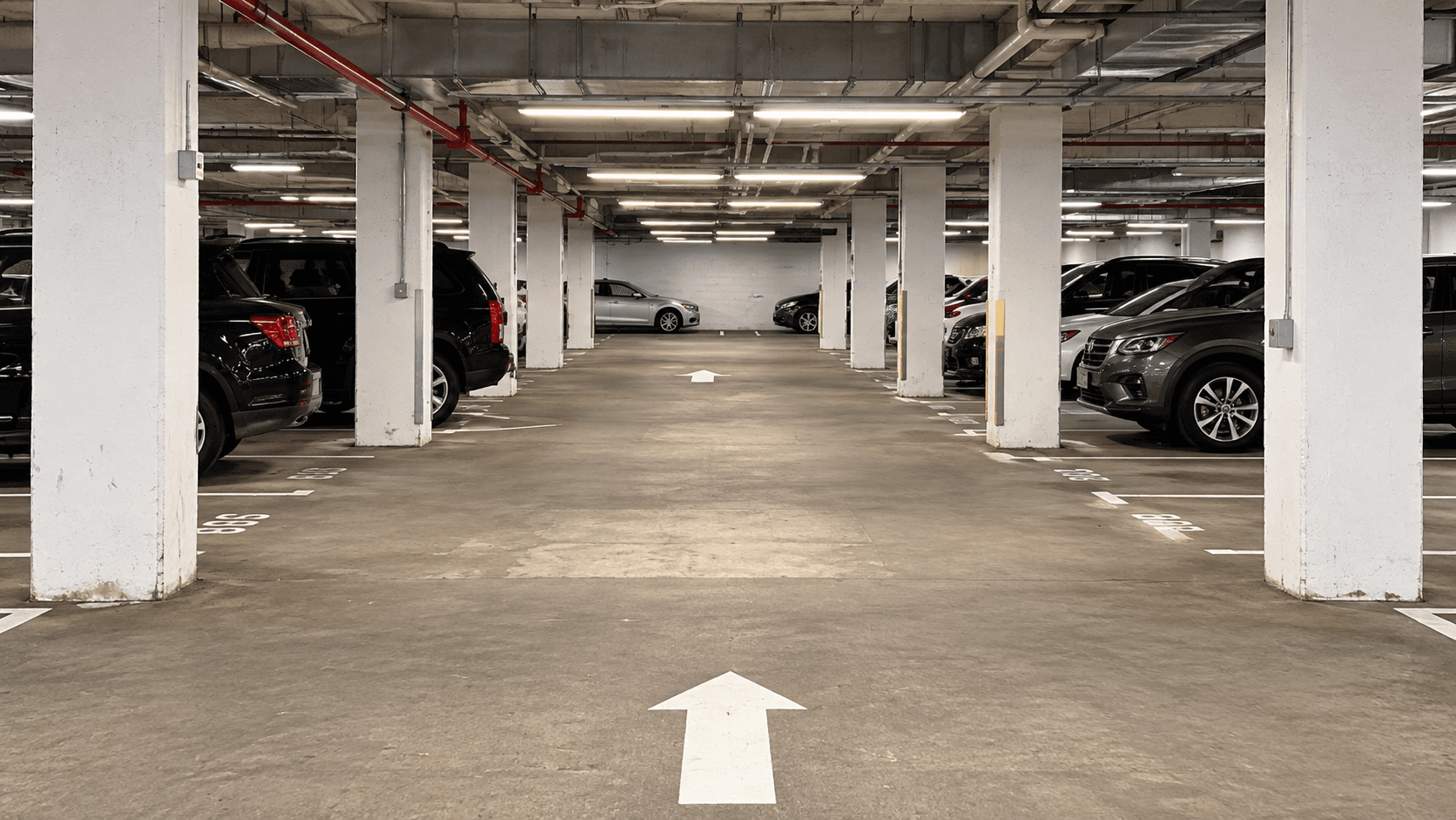 Freshly striped parking garage level with stall lines and directional arrows in the Bronx, NY