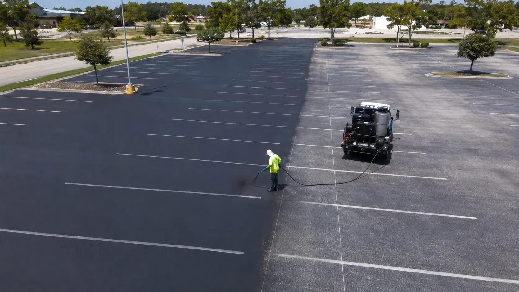 Commercial parking lot seal coating before and after, fresh black asphalt vs faded grey surface