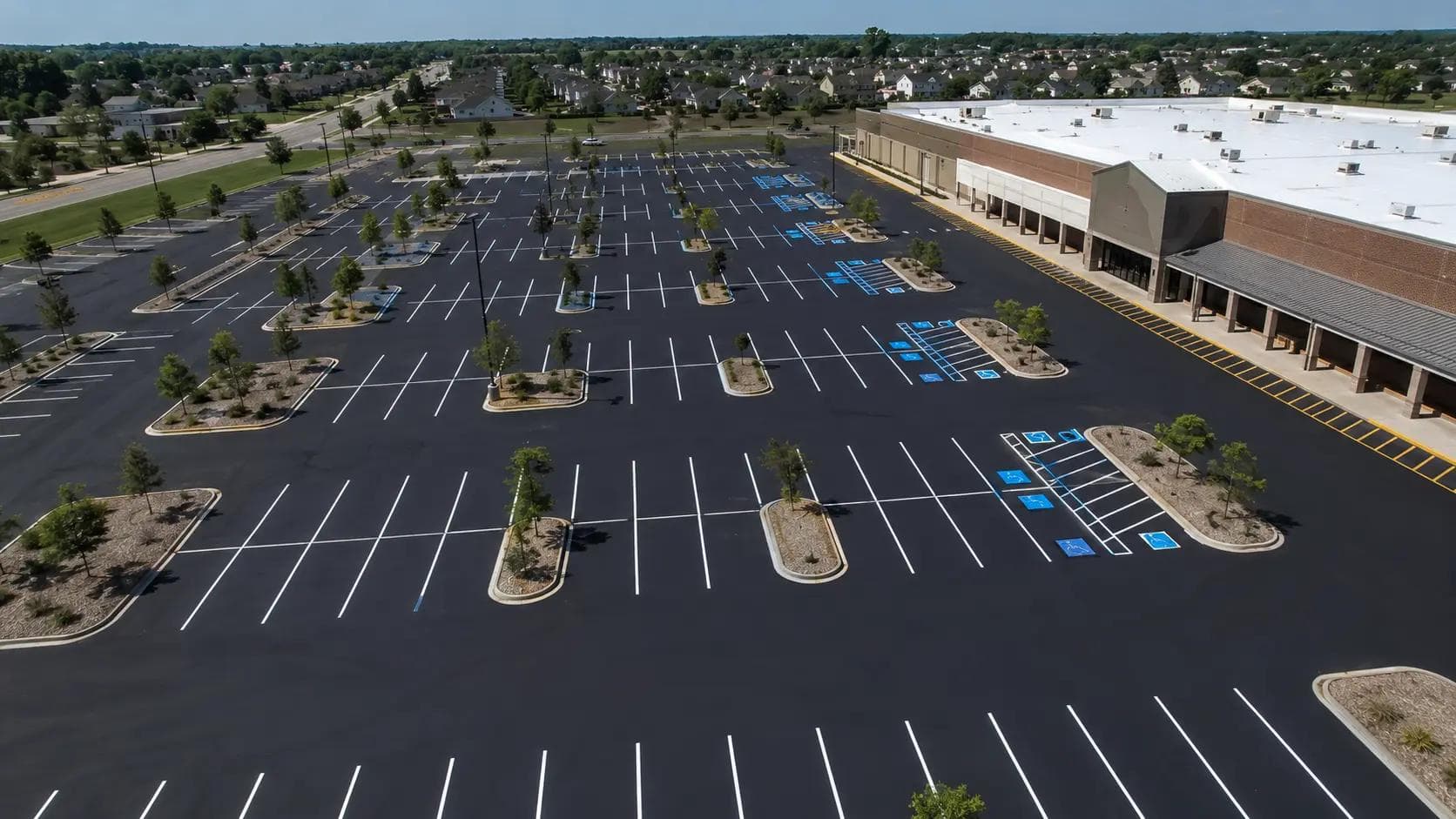 Freshly re-striped commercial parking lot with white stall lines, ADA markings, and fire lanes