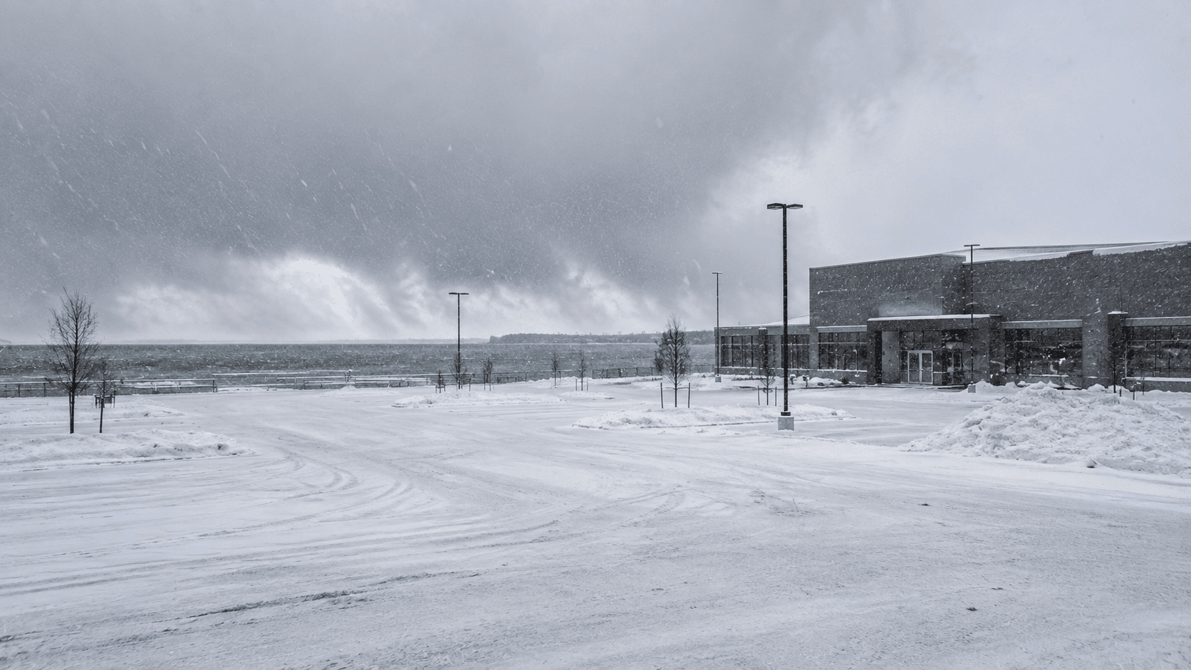 Heavy lake-effect snow band covering a commercial parking lot near a Great Lake